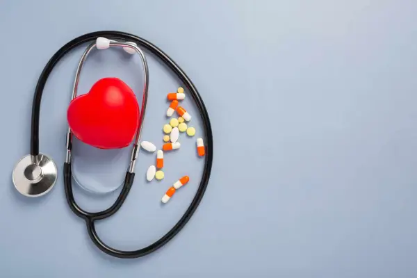 Stetoscopio, cuore rosso e pillole sparse. La cardioaspirina dopo i 70 anni è un tema importante per la salute cardiovascolare.